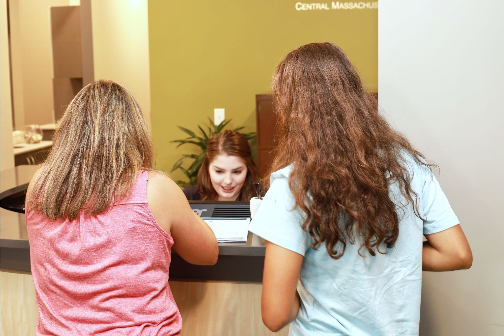 patients-checking-out-at-receptionists-desk patient at front desk